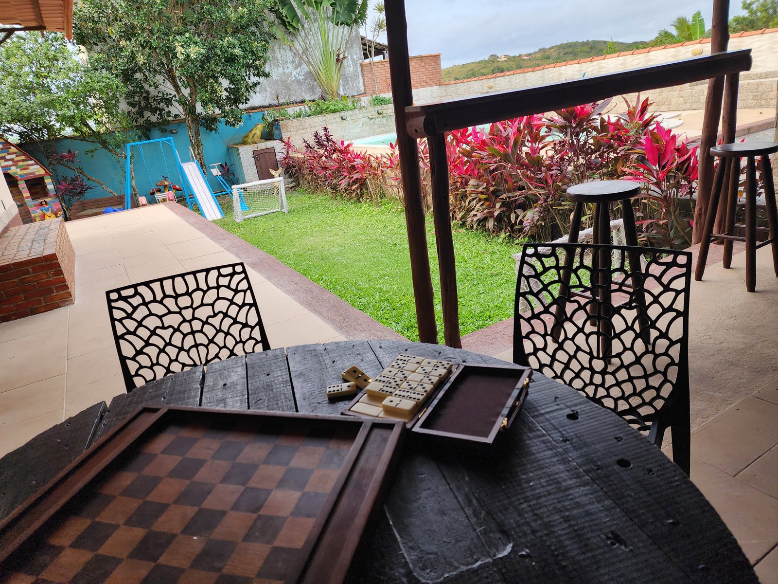 Varanda com mesa de jogos e churrasqueira