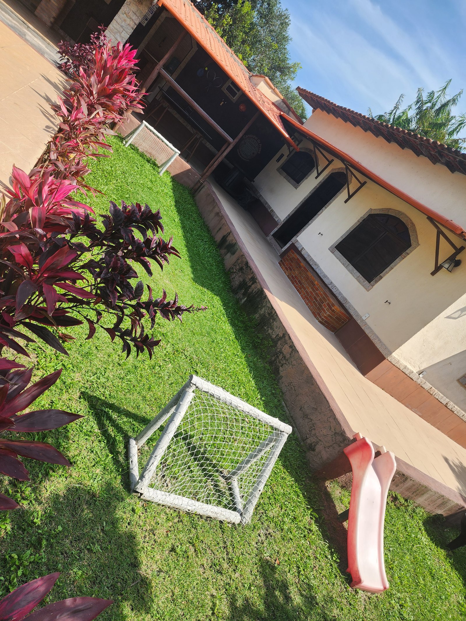 Jardim com brinquedos infantis e vista da piscina