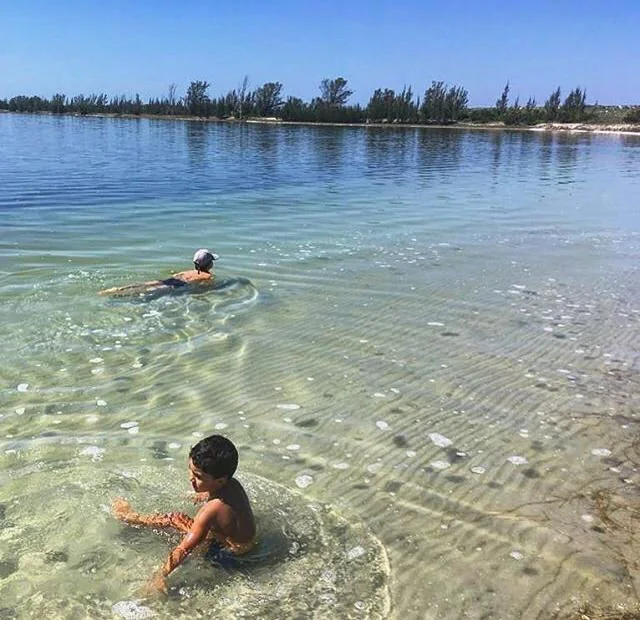 Banhistas nas águas rasas e transparentes da Lagoa Vermelha