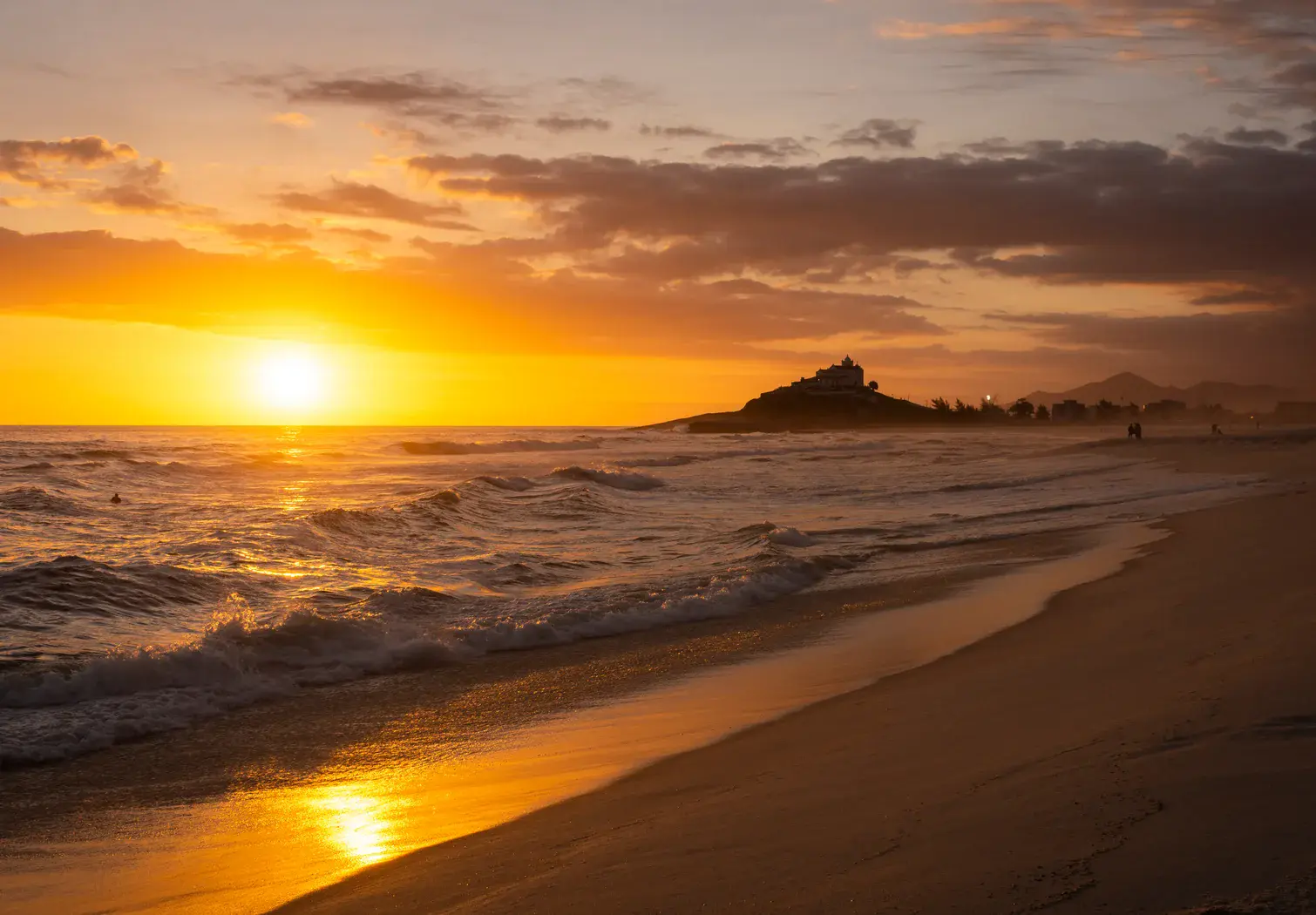 Praia iluminada pelo pôr do sol